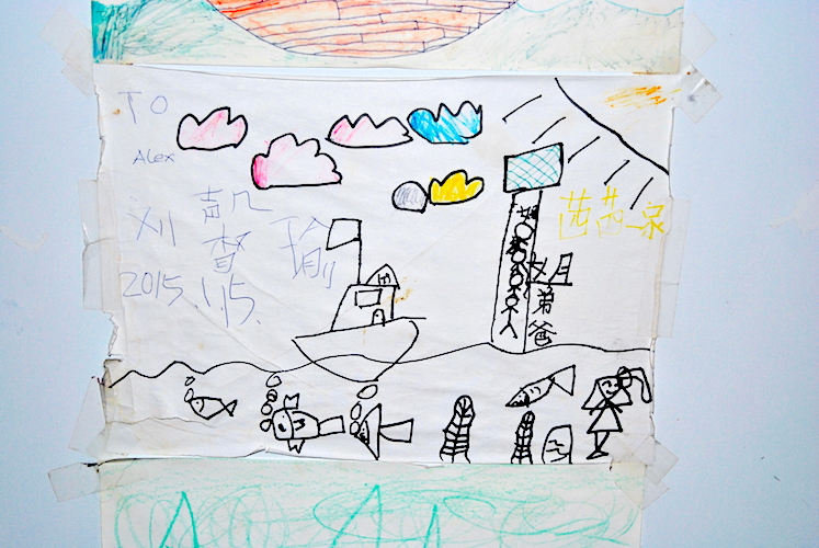 Kjøleskapet er dekket med tegninger fra barn fra hele verden, som denne fra Kina.