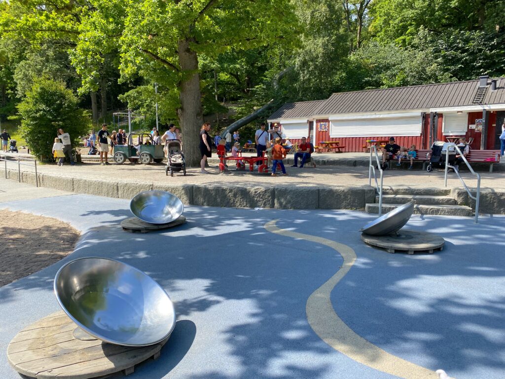Lekeapparater og barn i Gøteborg på Plikta lekeplass i Slottsskogen park. 