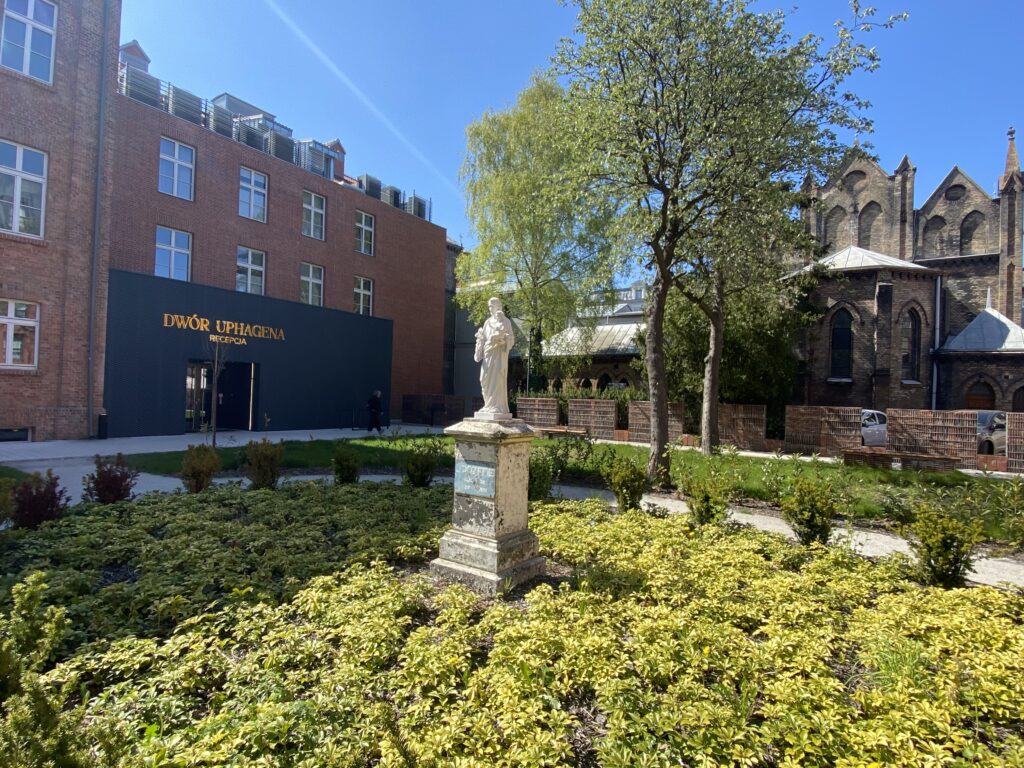 Hotellets grønne bakgård binder byggene sammen. Her er en park med statue og mye grønt.