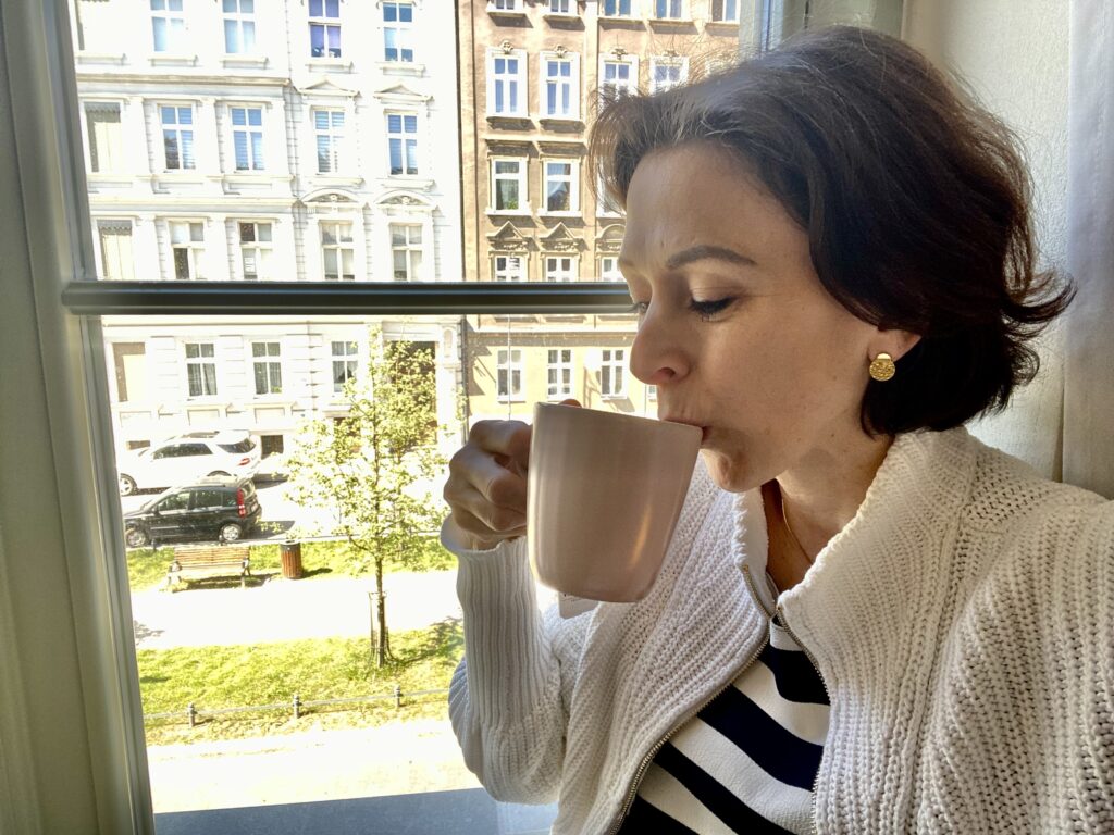 Kvinne drikker te på hotellrommet i Gdansk.