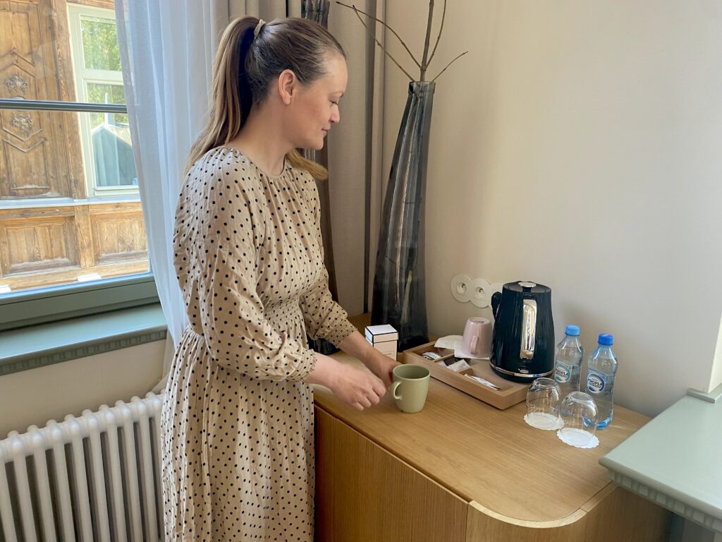 Kvinne lager seg te på et hotellrom ved Dwór Uphagena i Gdansk.